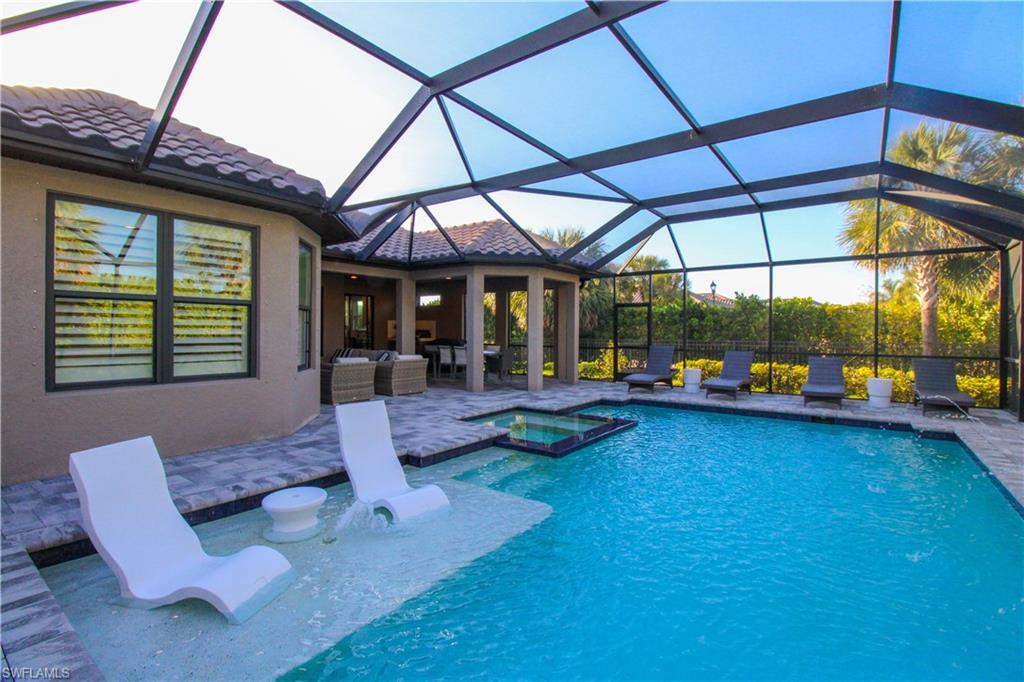 View of swimming pool with an in ground hot tub, outdoor lounge area, a patio, and glass enclosure