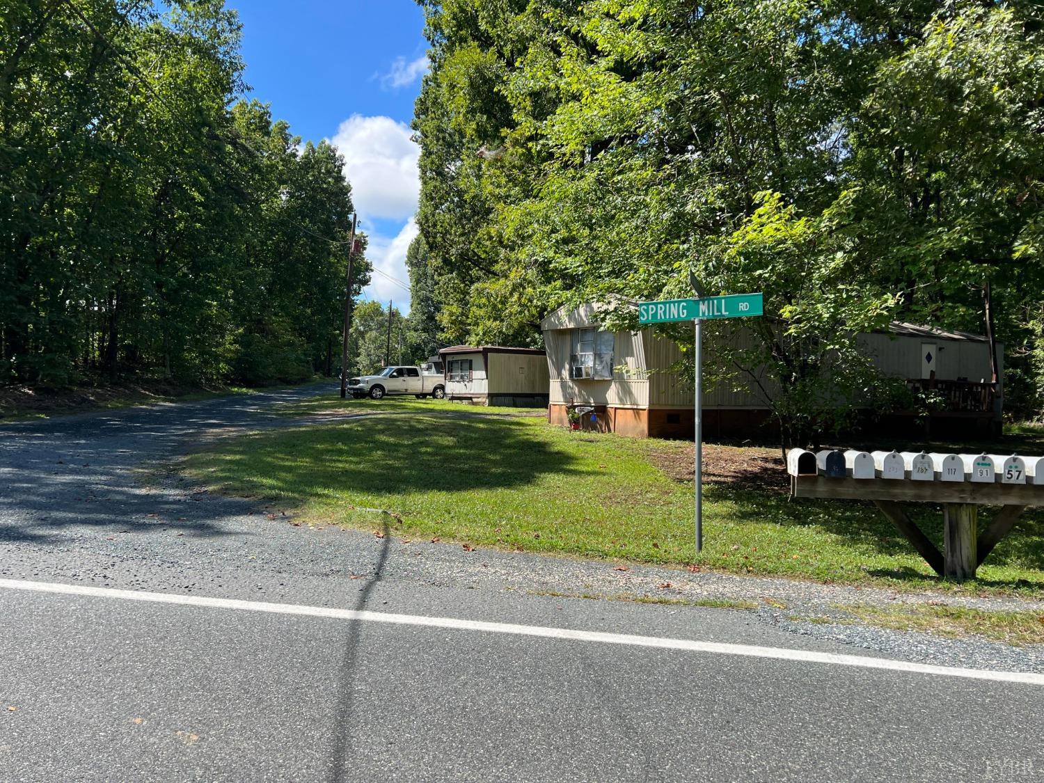 a view of a house with a yard and large parking space