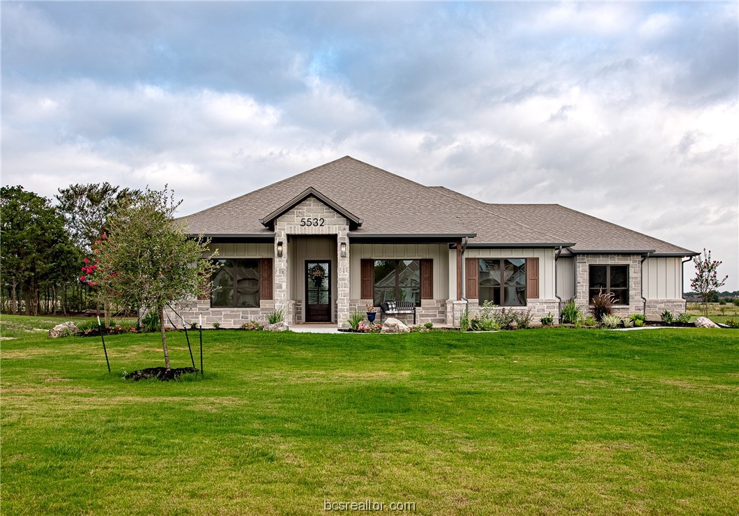 a front view of a house with a garden