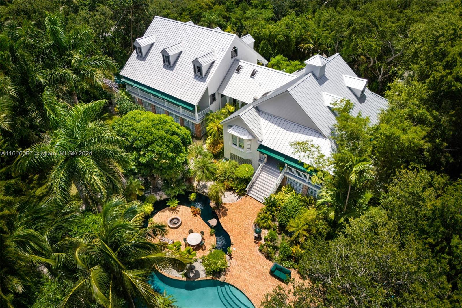 an aerial view of a house with a yard and large trees