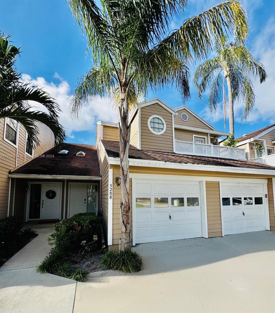 a front view of a house with palm tree