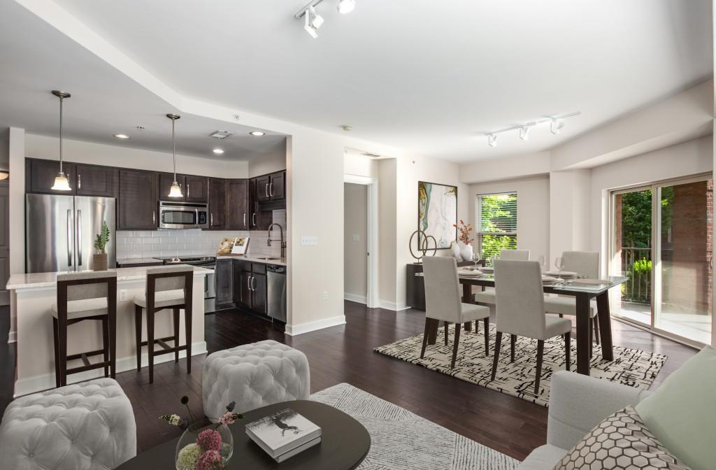 a living room with furniture kitchen view and a large window