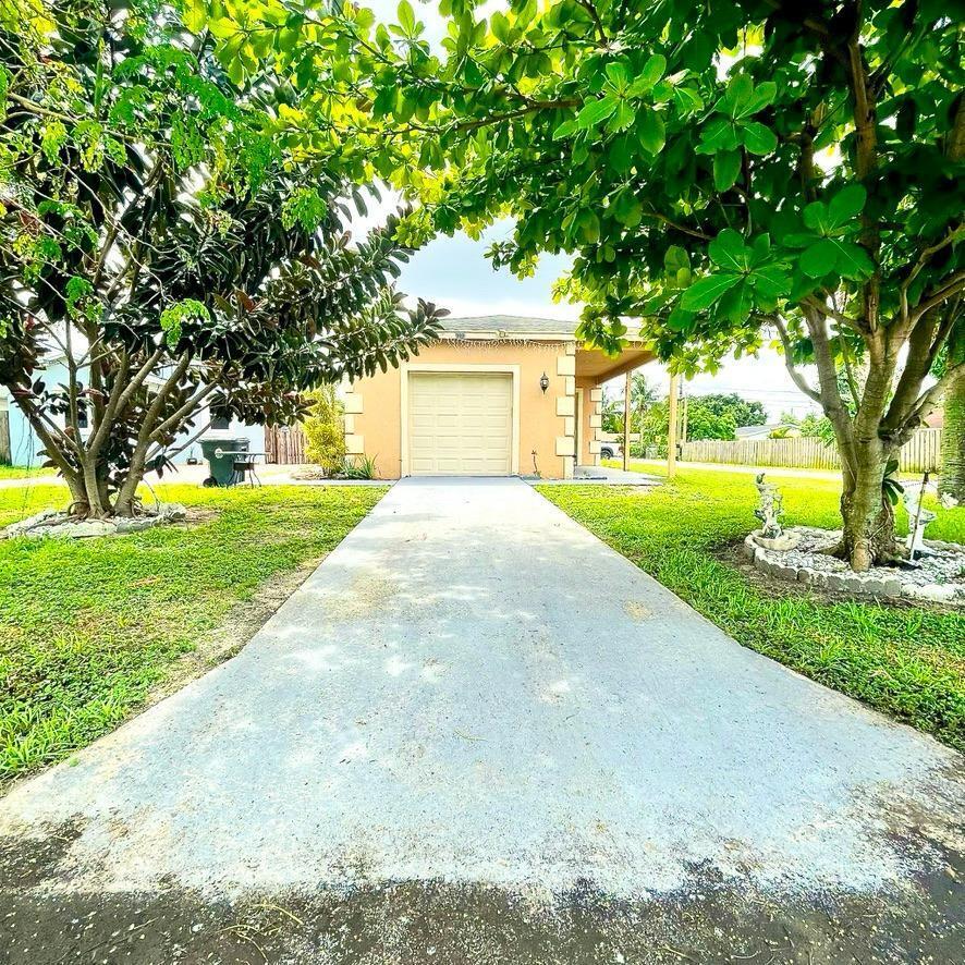 a front view of a house with yard and green space