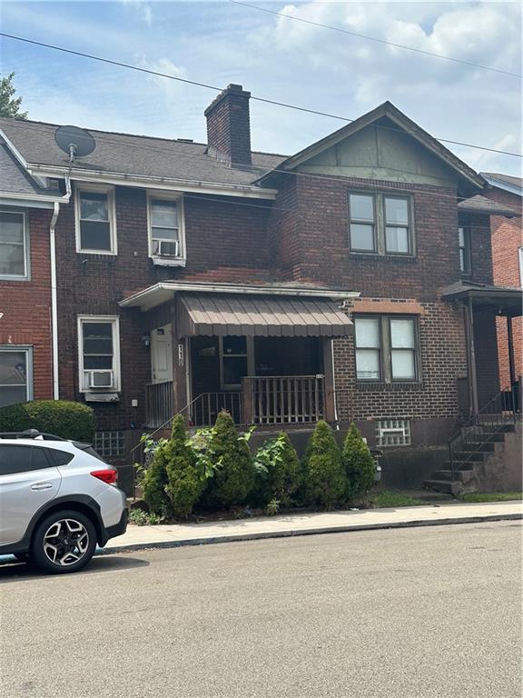 a view of a car parked in front of a brick house