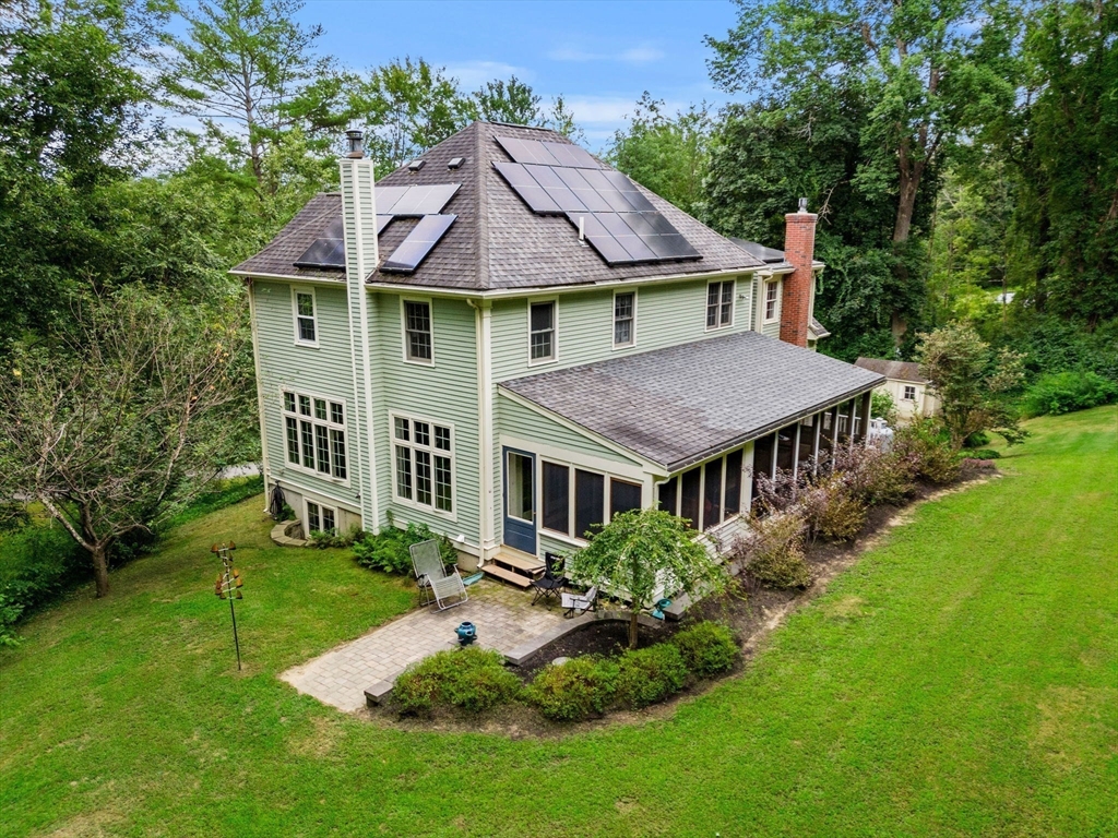 a aerial view of a house next to a big yard and large trees