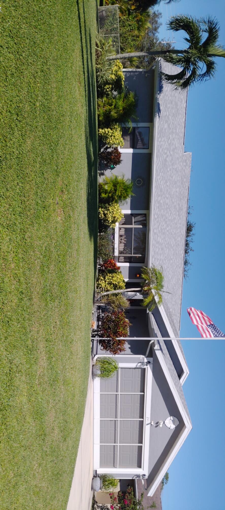 a front view of a house with a yard and potted plants