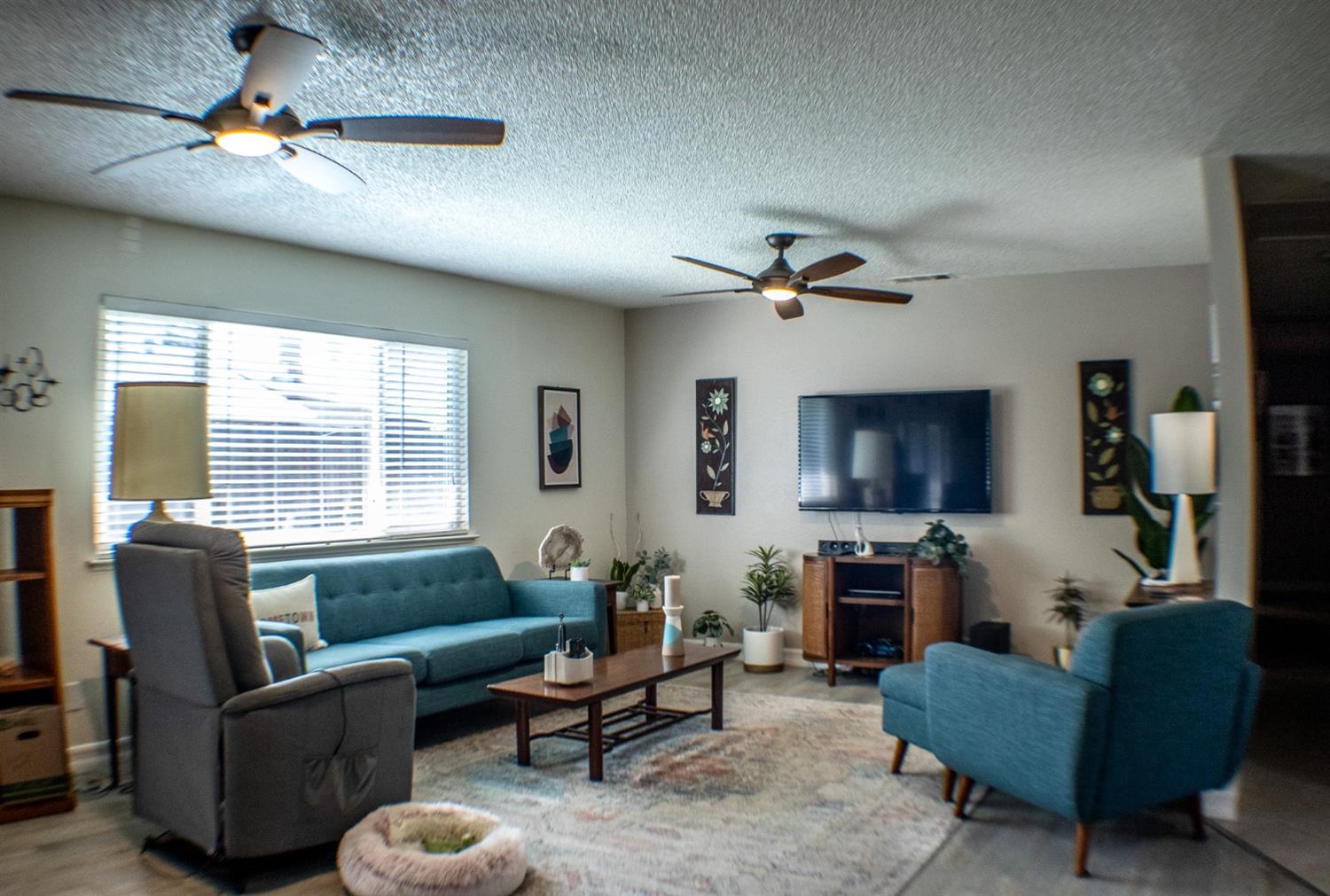 a living room with furniture a flat screen tv and a window