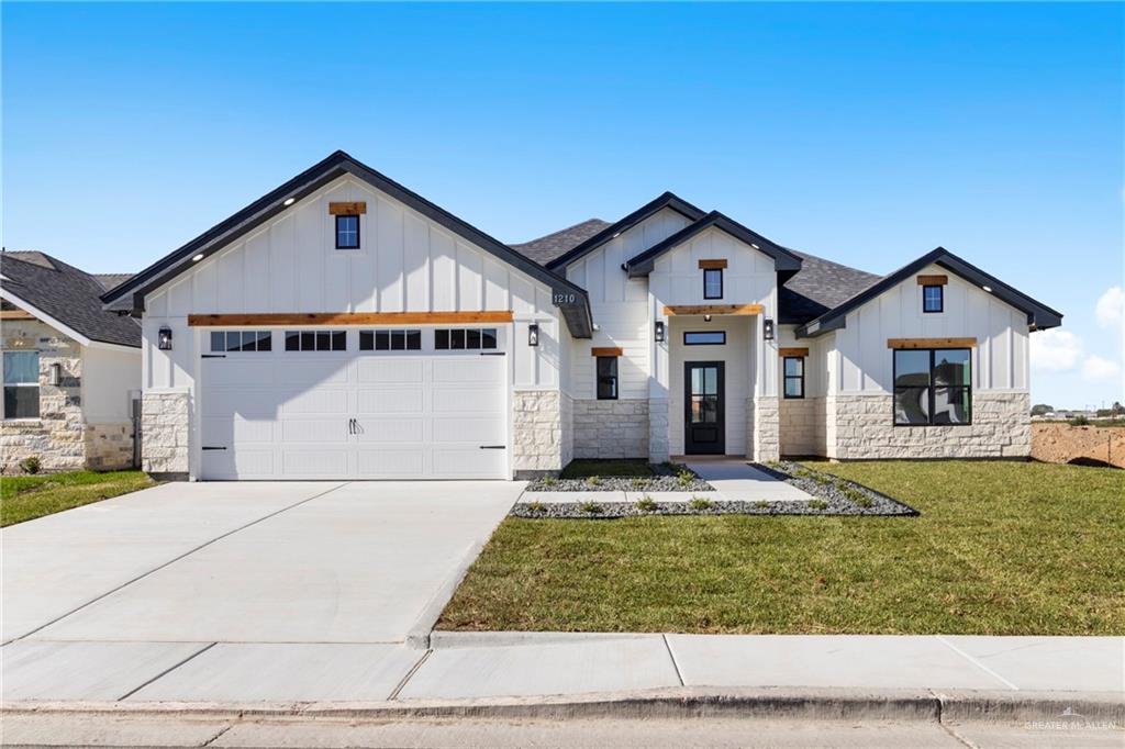 Modern farmhouse with a garage and a front lawn