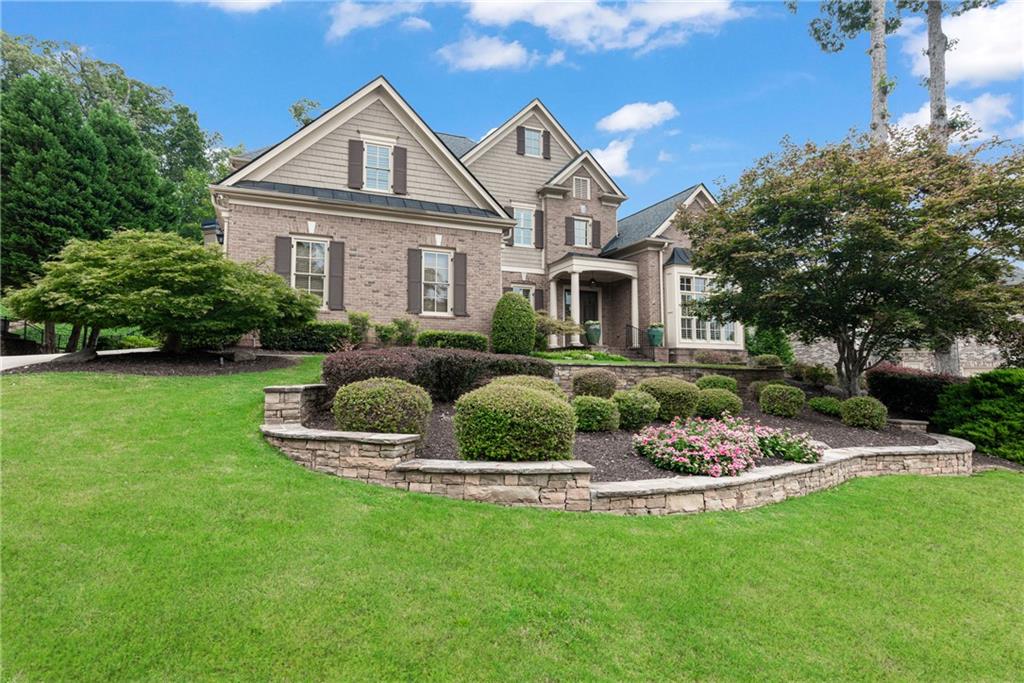 a front view of a house with a garden and yard