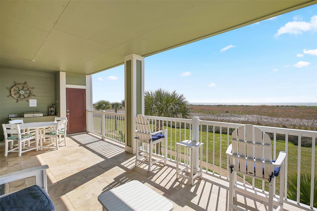 a view of a balcony with wooden floor and furniture