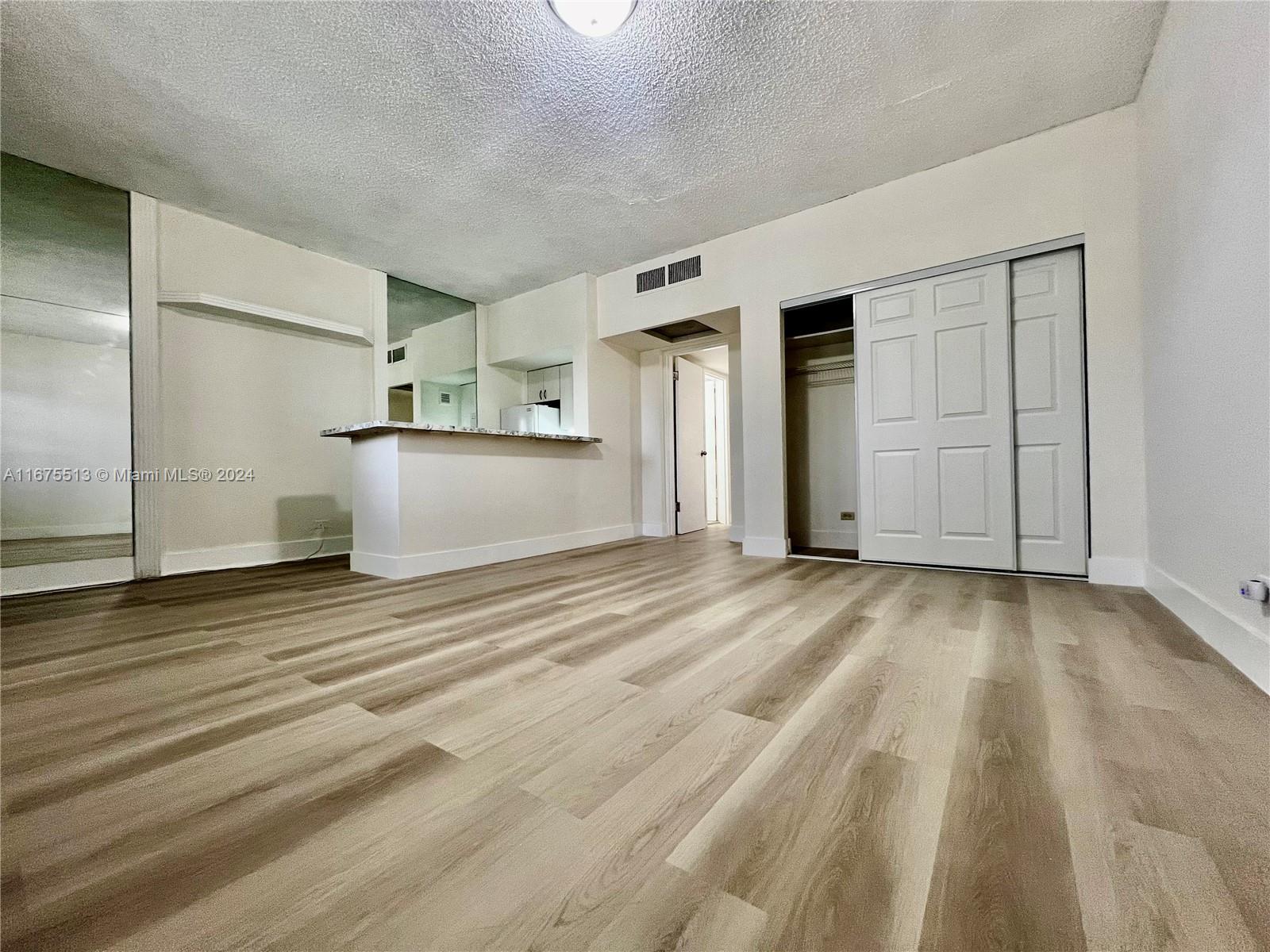 an empty room with wooden floor and white doors