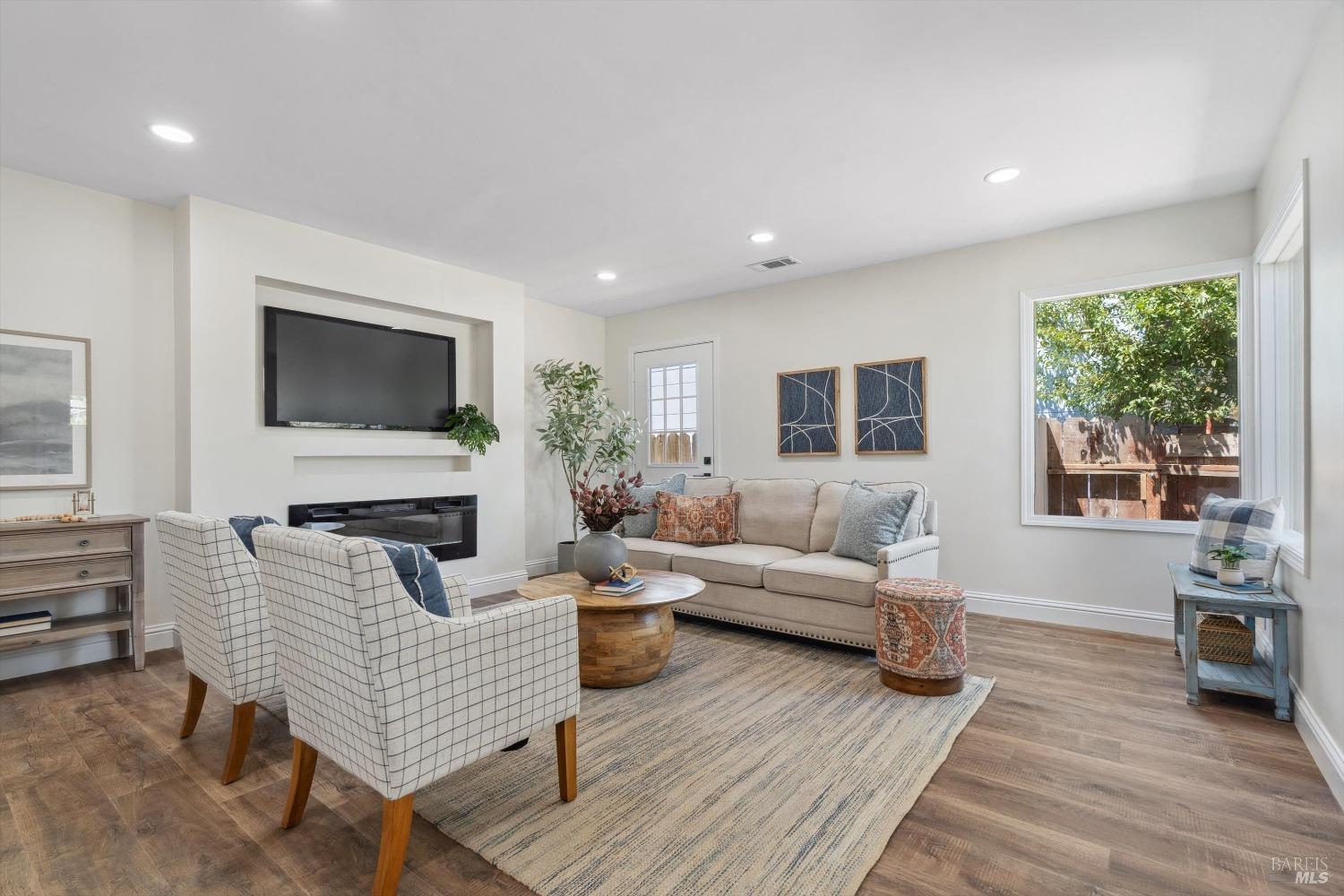 a living room with furniture a fireplace and a flat screen tv