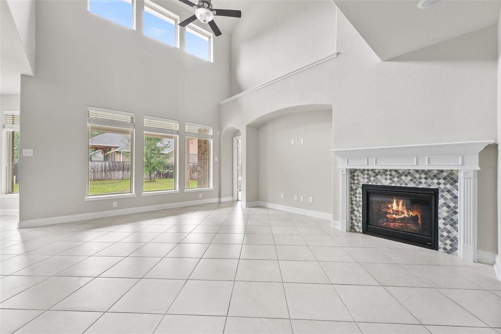 a view of an empty room with a fireplace and window