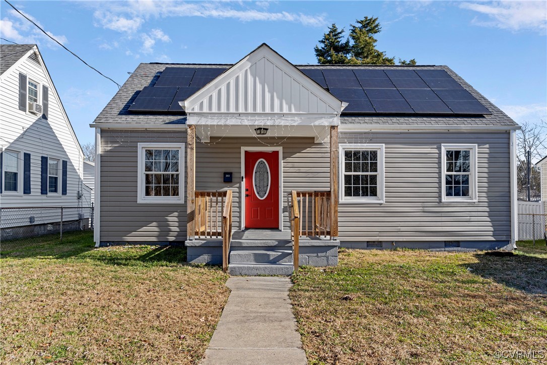 Bungalow featuring solar panels and a front lawn