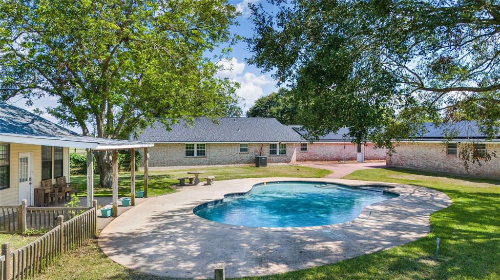 a view of a house with swimming pool and porch with furniture