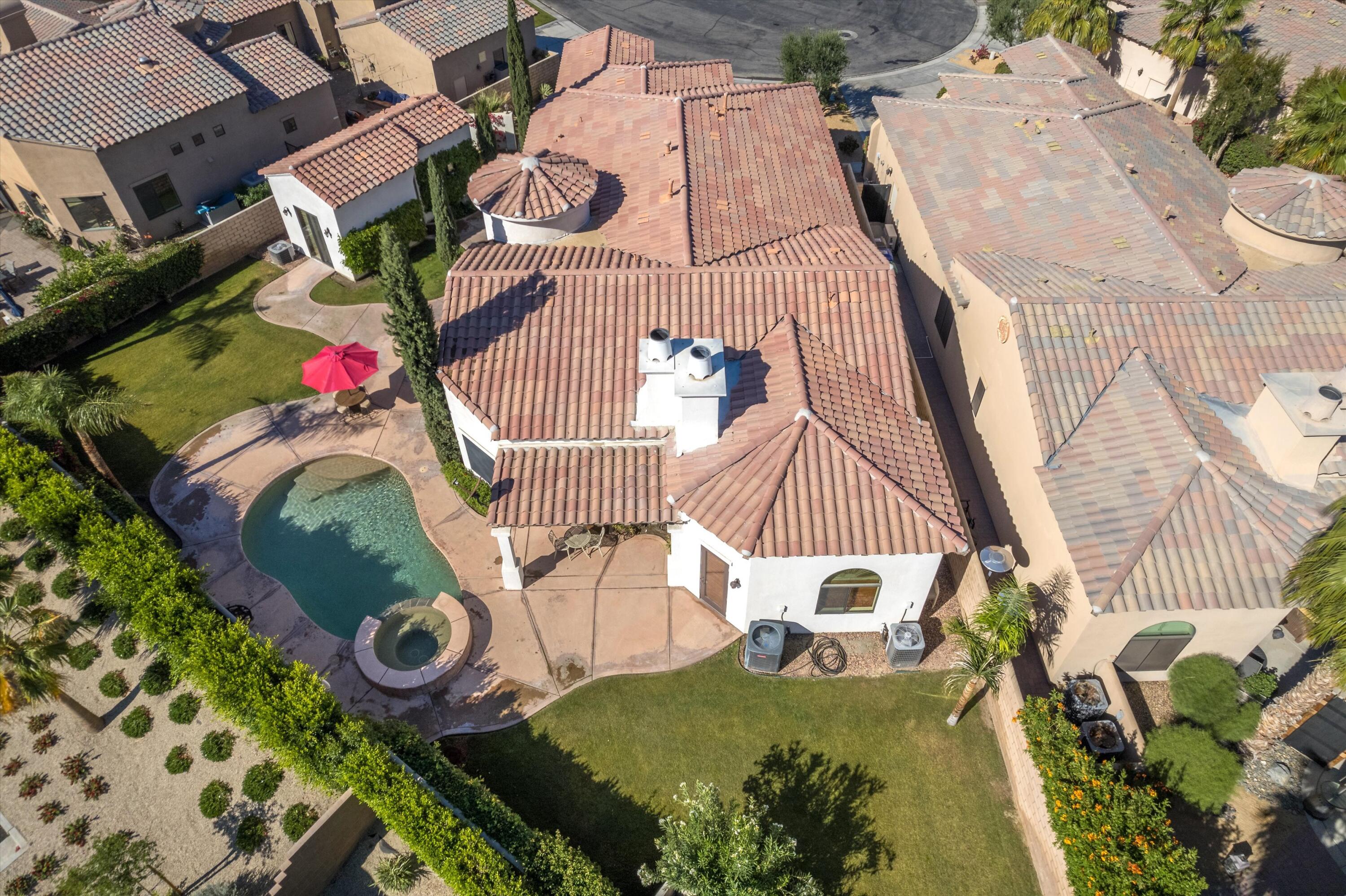 an aerial view of a house with swimming pool and wooden fence