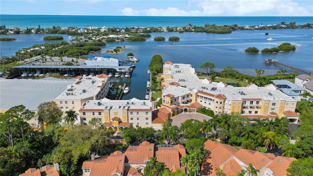 an aerial view of ocean and residential houses with outdoor space