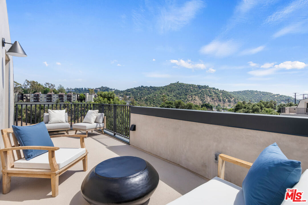 a view of roof deck with furniture and city view