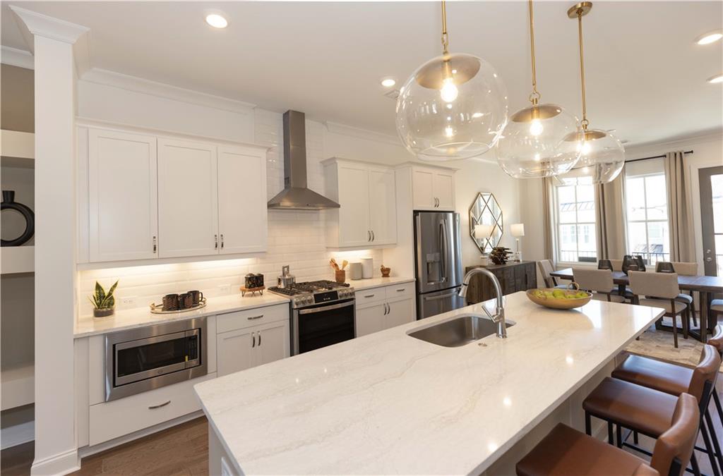 a kitchen that has a sink a stove and chairs