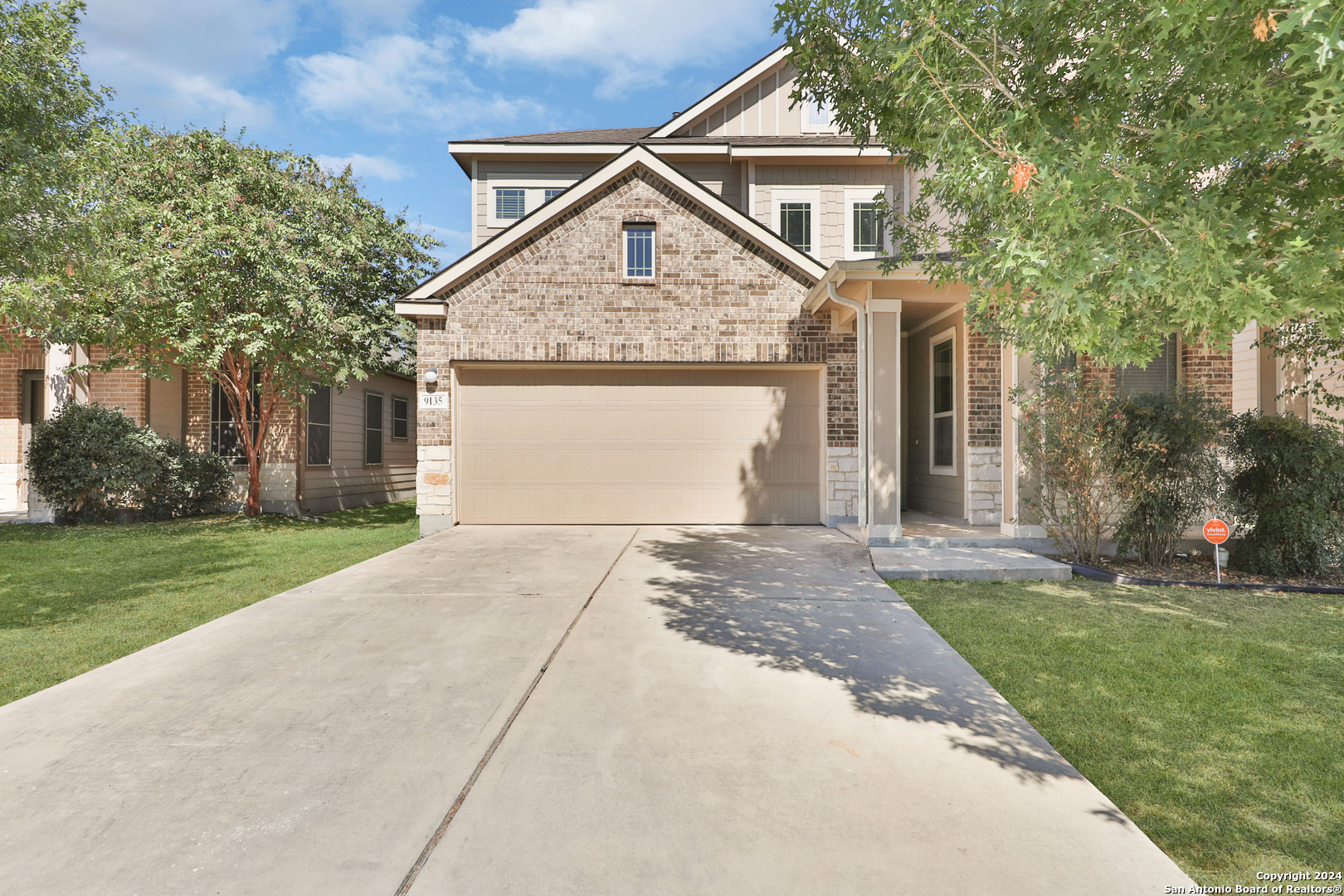 a front view of a house with a yard and trees