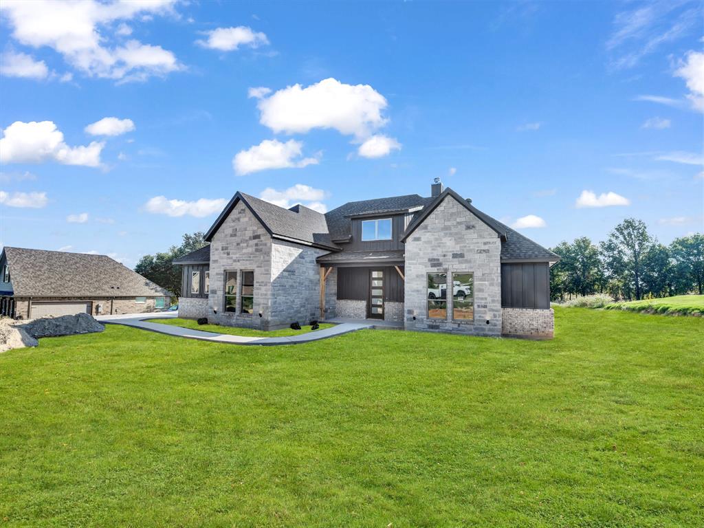 a view of a house with a big yard and a large tree