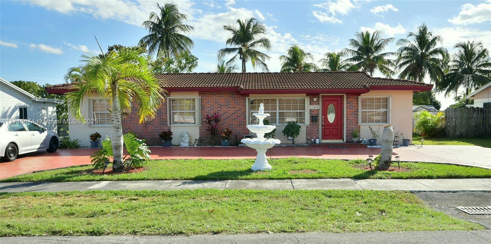 a view of a house with a yard and palm trees