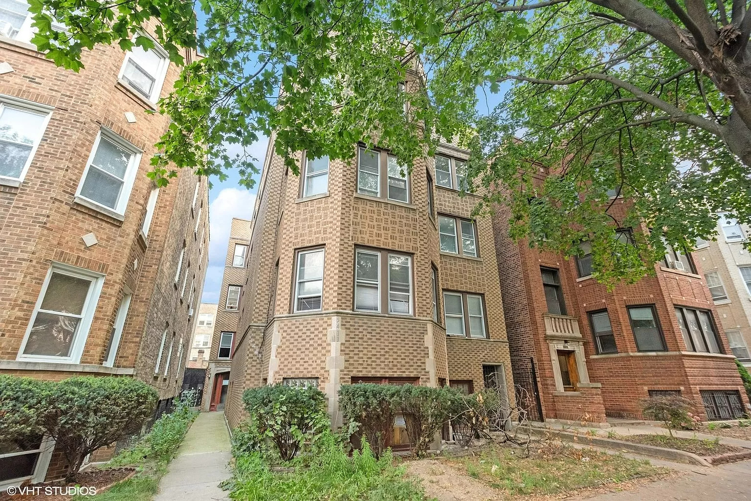 a front view of a residential apartment building with a yard