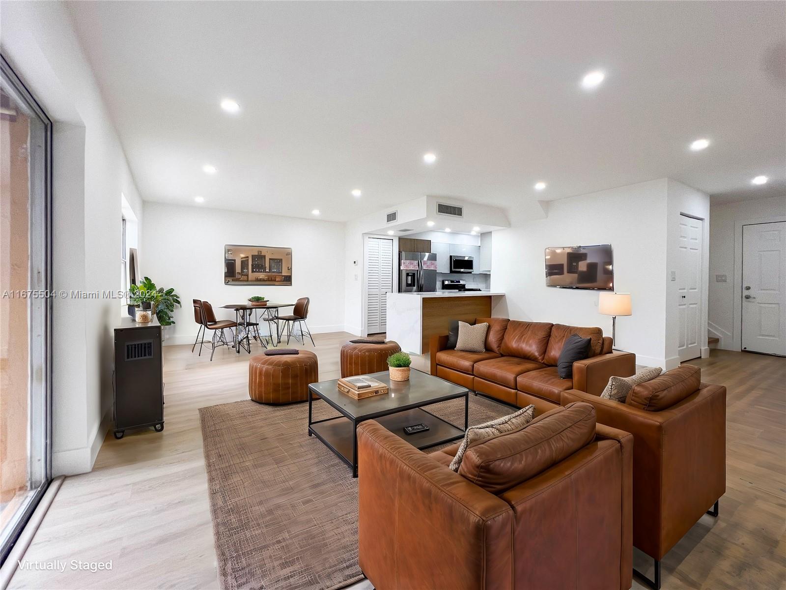 a living room with furniture and kitchen view