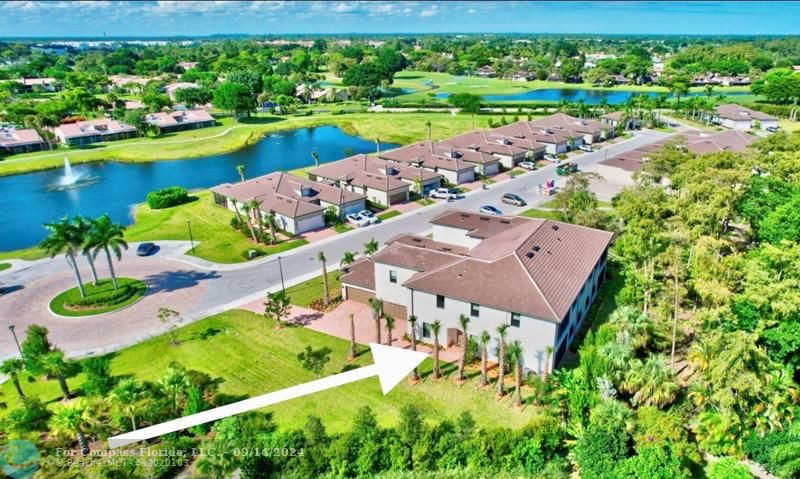 an aerial view of a house with a garden and lake view