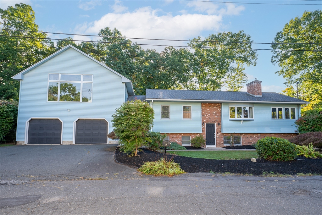 a view of house with a yard and a large tree