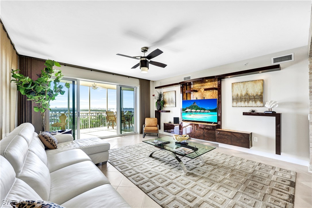 a living room with furniture a flat screen tv and a large window