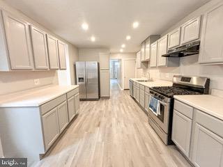 a kitchen with kitchen island granite countertop a sink a counter top space stainless steel appliances and cabinets