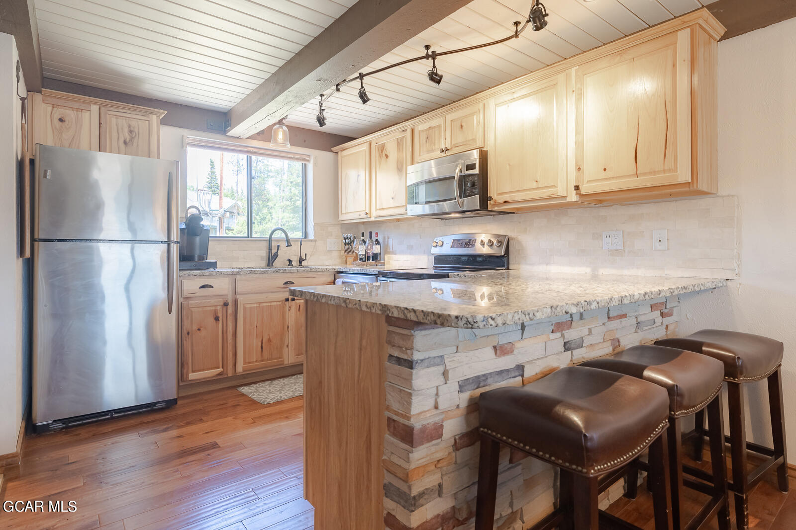 a kitchen with stainless steel appliances granite countertop a white cabinets and a refrigerator