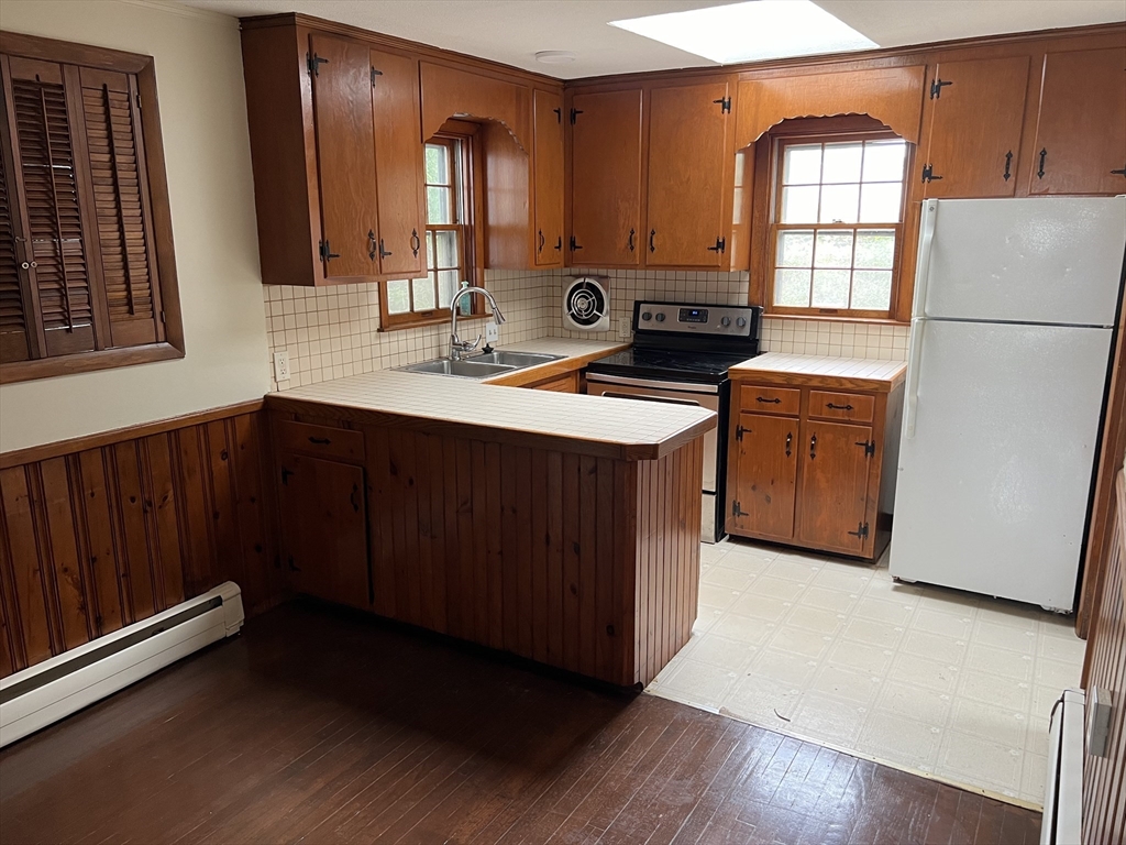 a kitchen with stainless steel appliances granite countertop a refrigerator a sink dishwasher and wooden cabinets