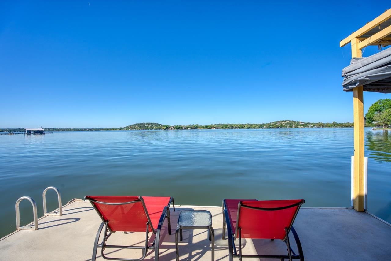 a view of a lake with table and chairs