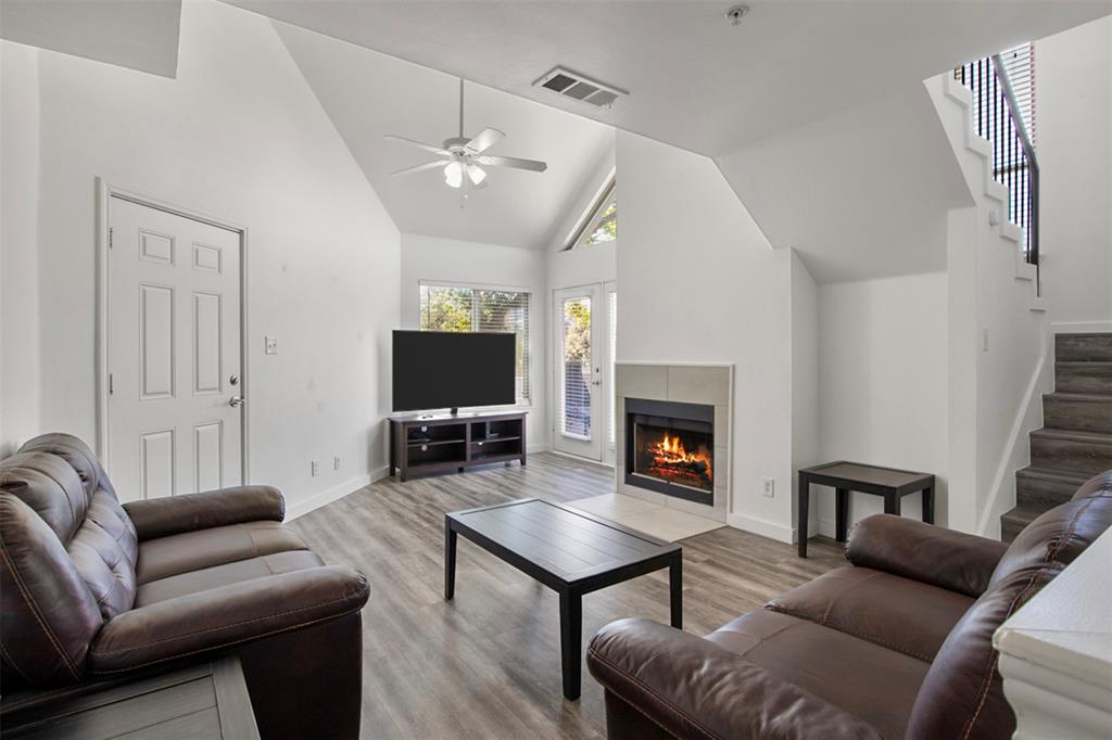 a living room with furniture a fireplace and a flat screen tv