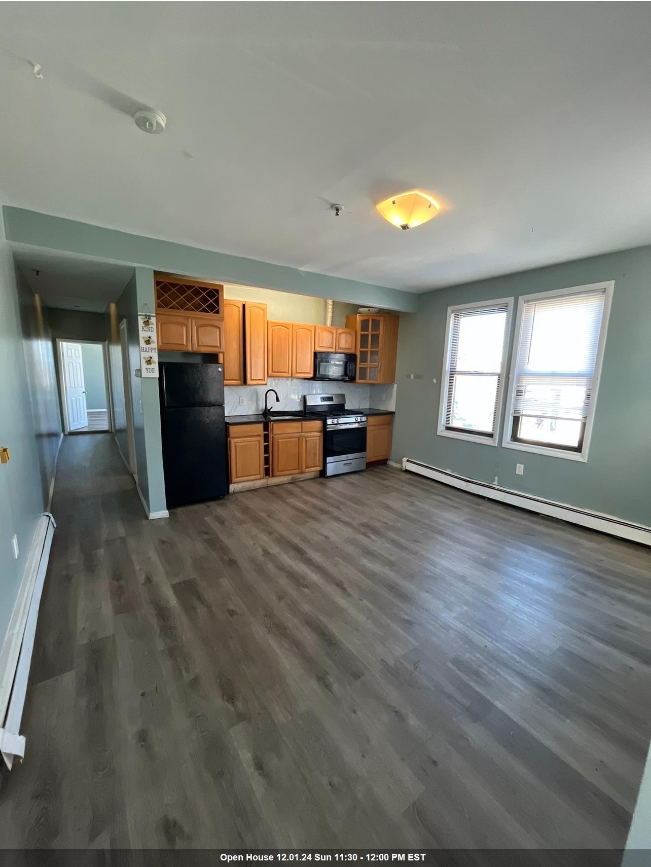 an empty room with windows wooden floor and chandelier