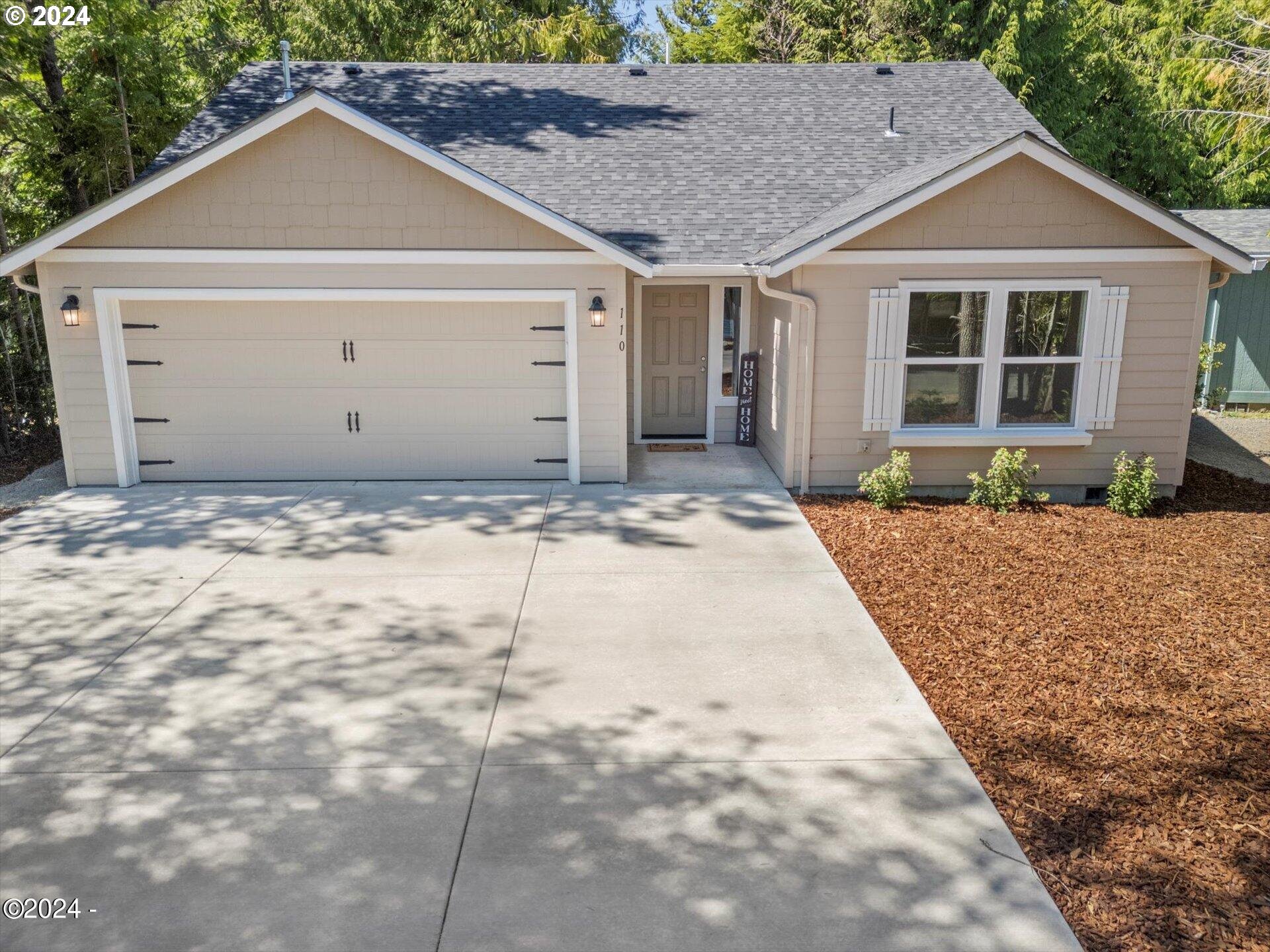 a front view of a house with a yard and garage