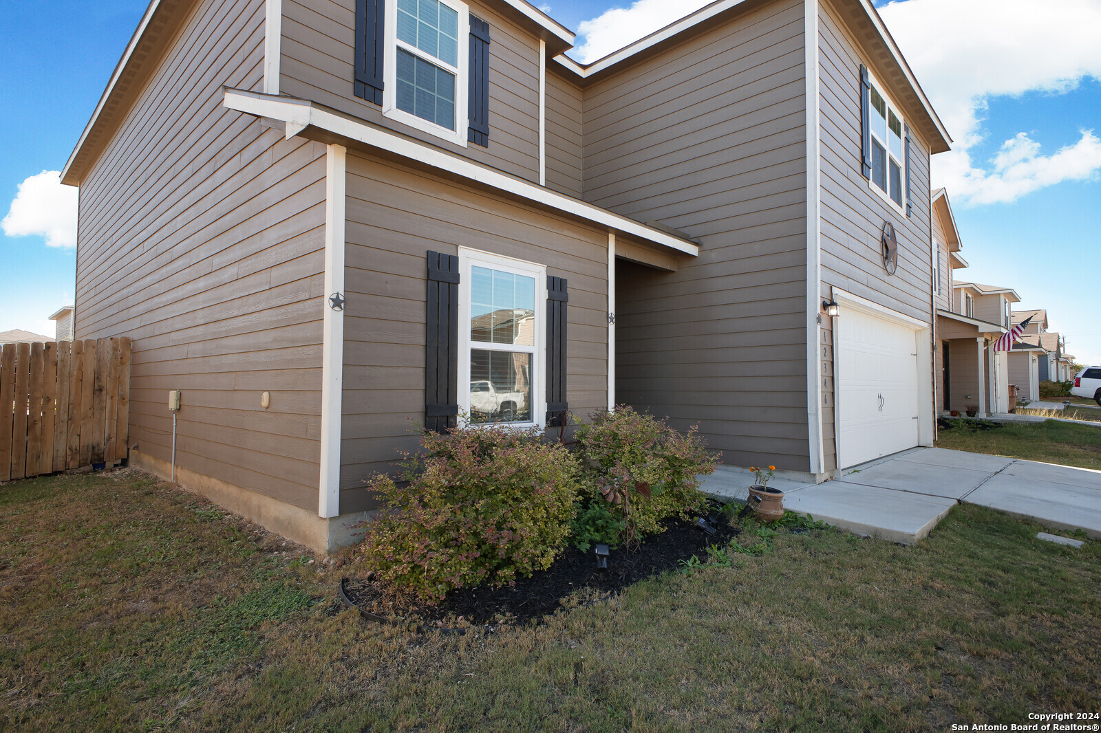 a view of a house with brick walls and a yard