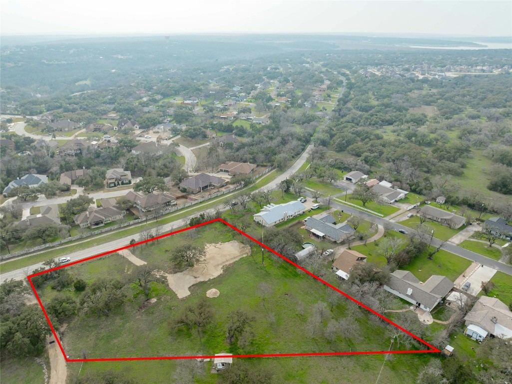 an aerial view of residential houses with outdoor space and trees