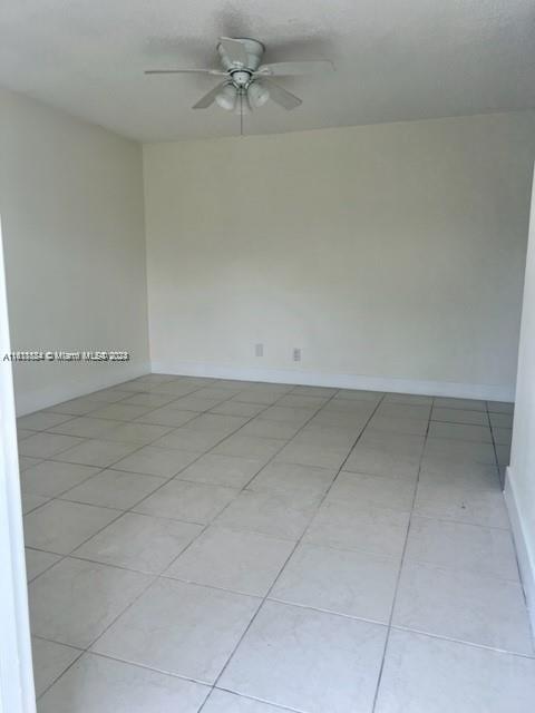 an empty room with a ceiling fan and carpet