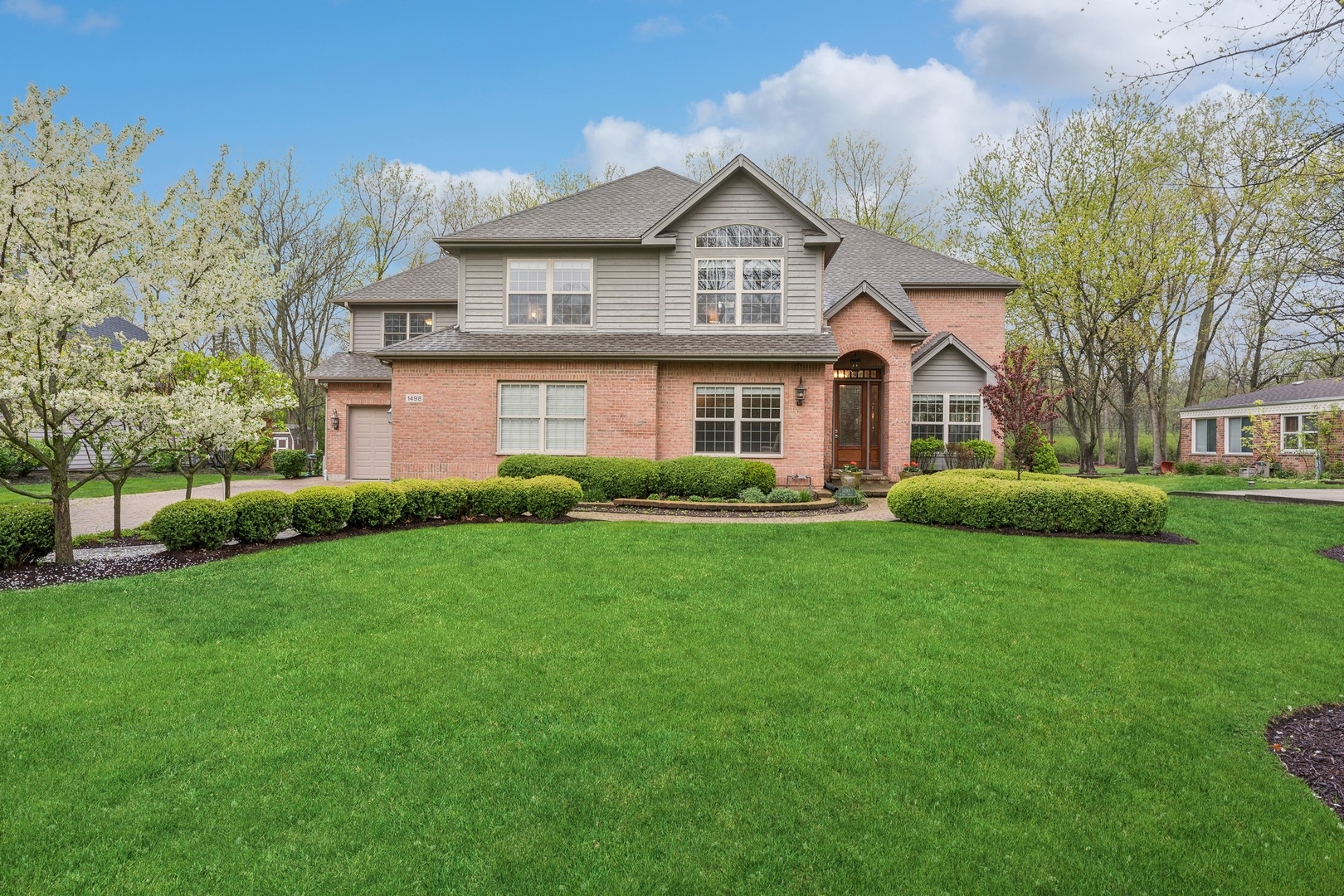 a front view of a house with a yard and trees