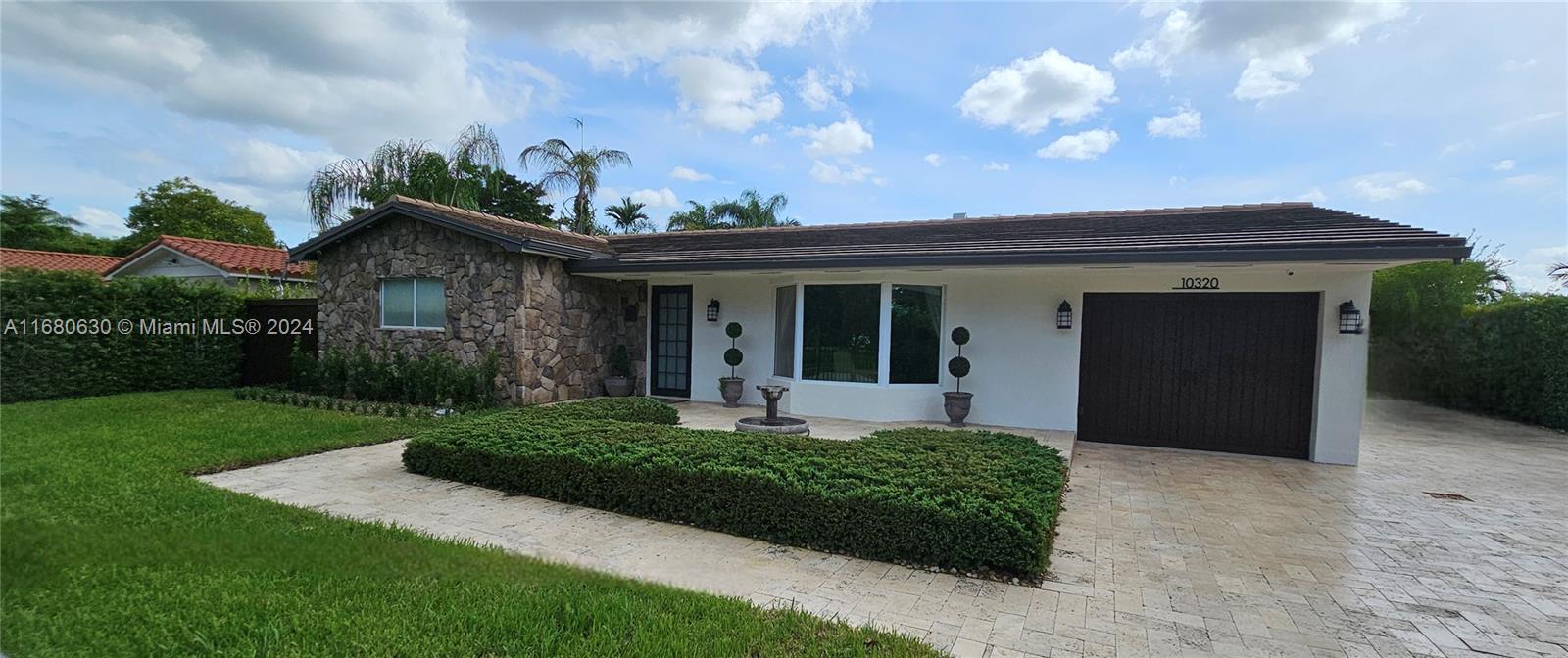 a front view of a house with a garden