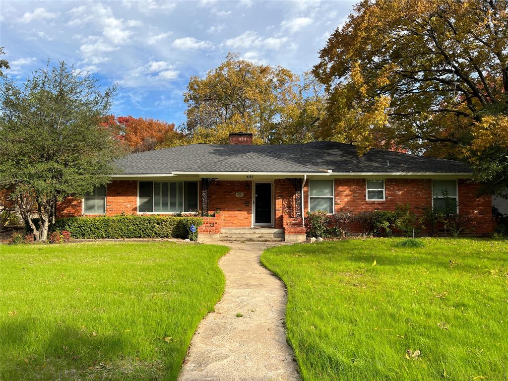 a front view of a house with a garden and trees