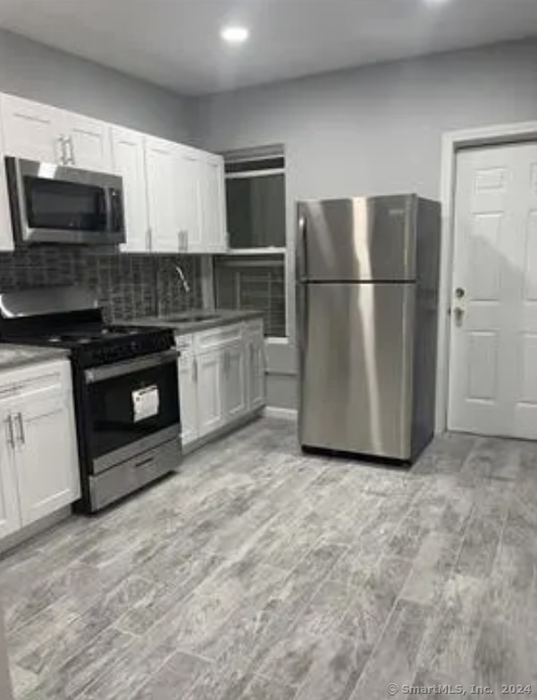 a kitchen with stainless steel appliances granite countertop a refrigerator stove and microwave