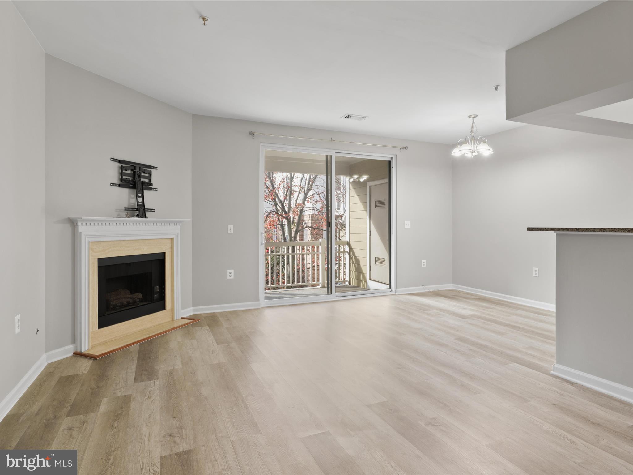 an empty room with windows and fireplace