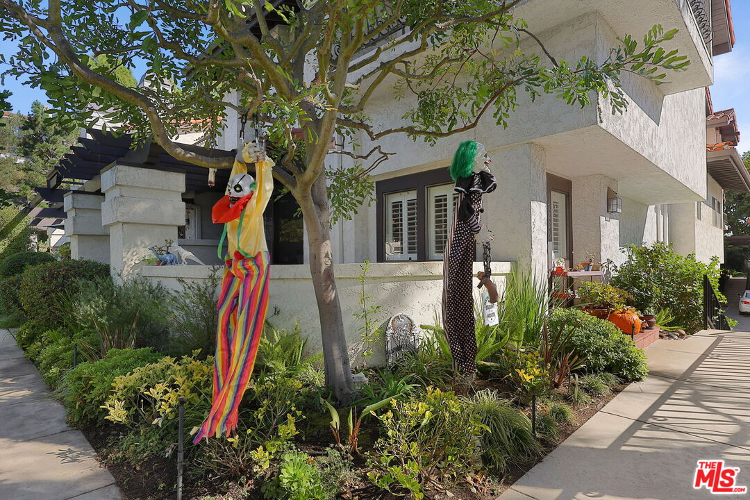 a front view of a house with a yard and potted plants