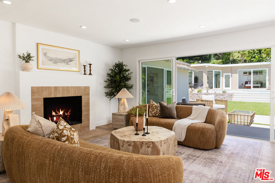 a living room with fireplace furniture and a large window