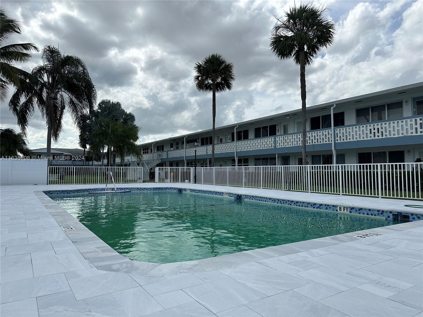 a view of swimming pool with a yard and large trees