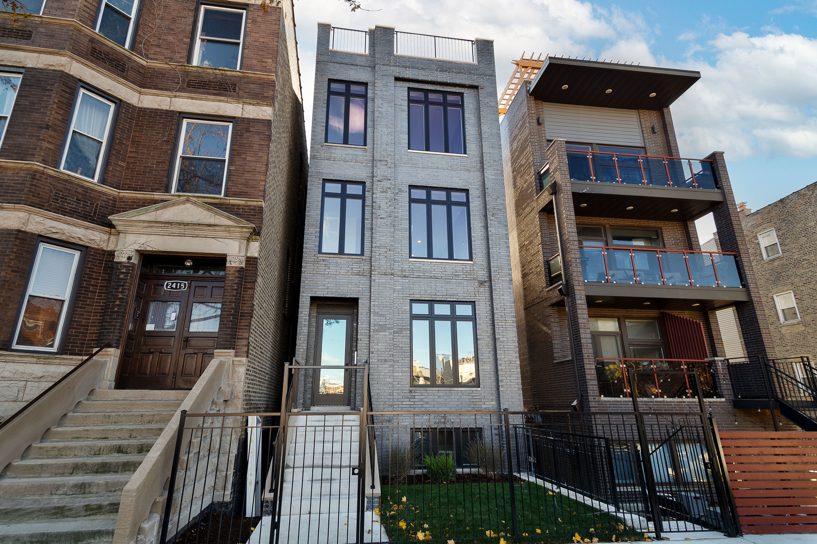 a front view of a residential apartment building with a yard